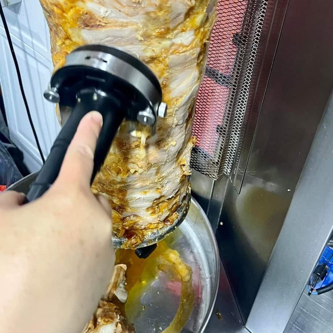 manos cortando carne de kebab